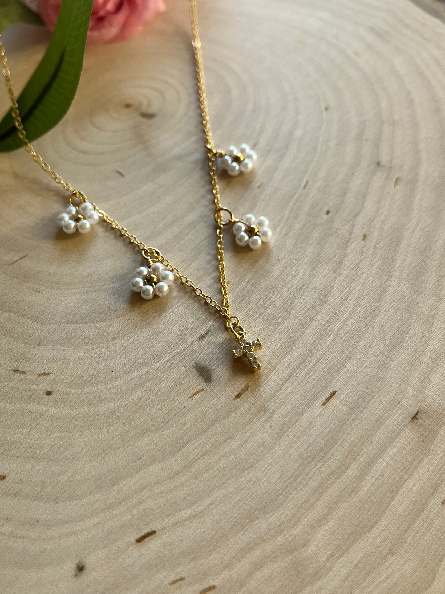Gold Necklace with 16K gold pendant featuring daisies and a cross.