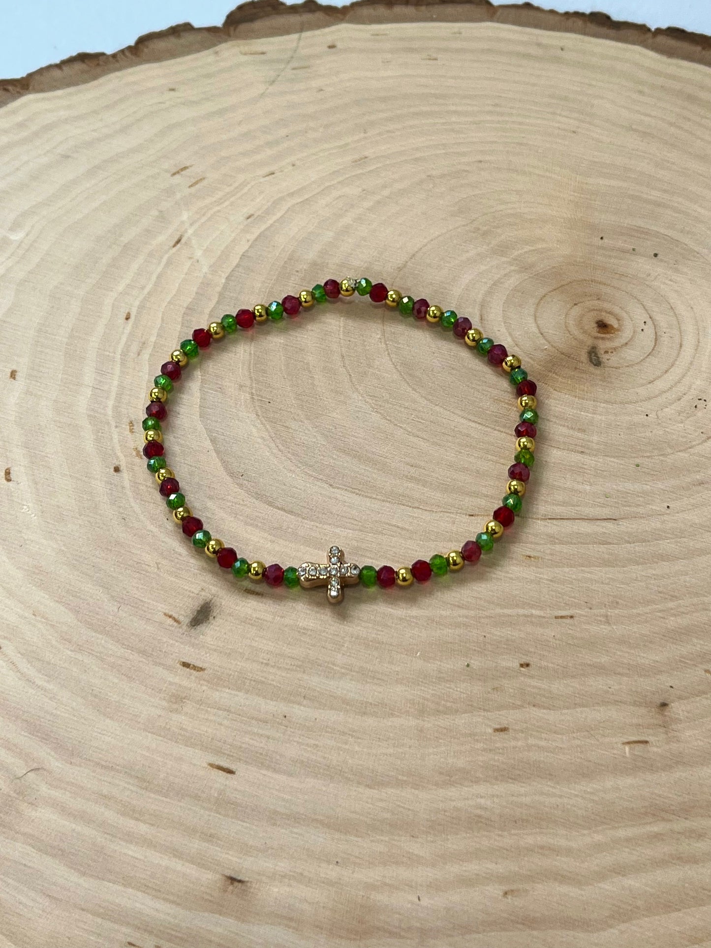Christmas cross bracelet with red and green crystal beads and gold cross charm.