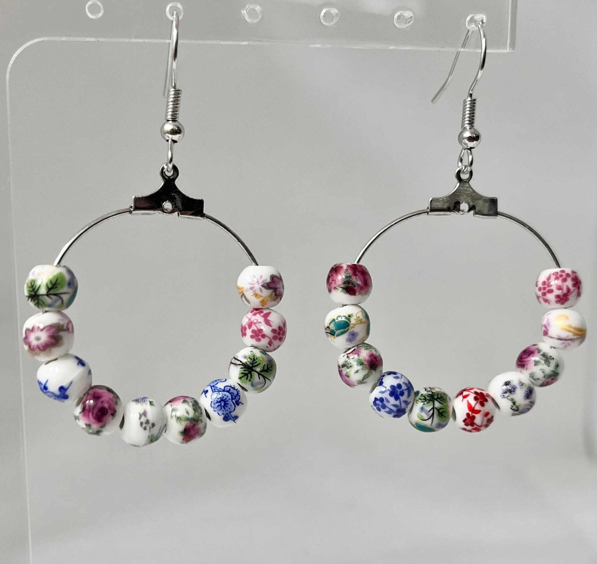Floral hoop earrings – multicolored beaded silver jewelry with a floral design.

