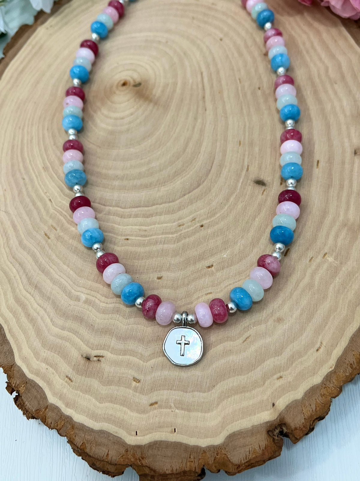 Christian cross necklace with colorful stone beads, silver accents, and pearlescent cross charm