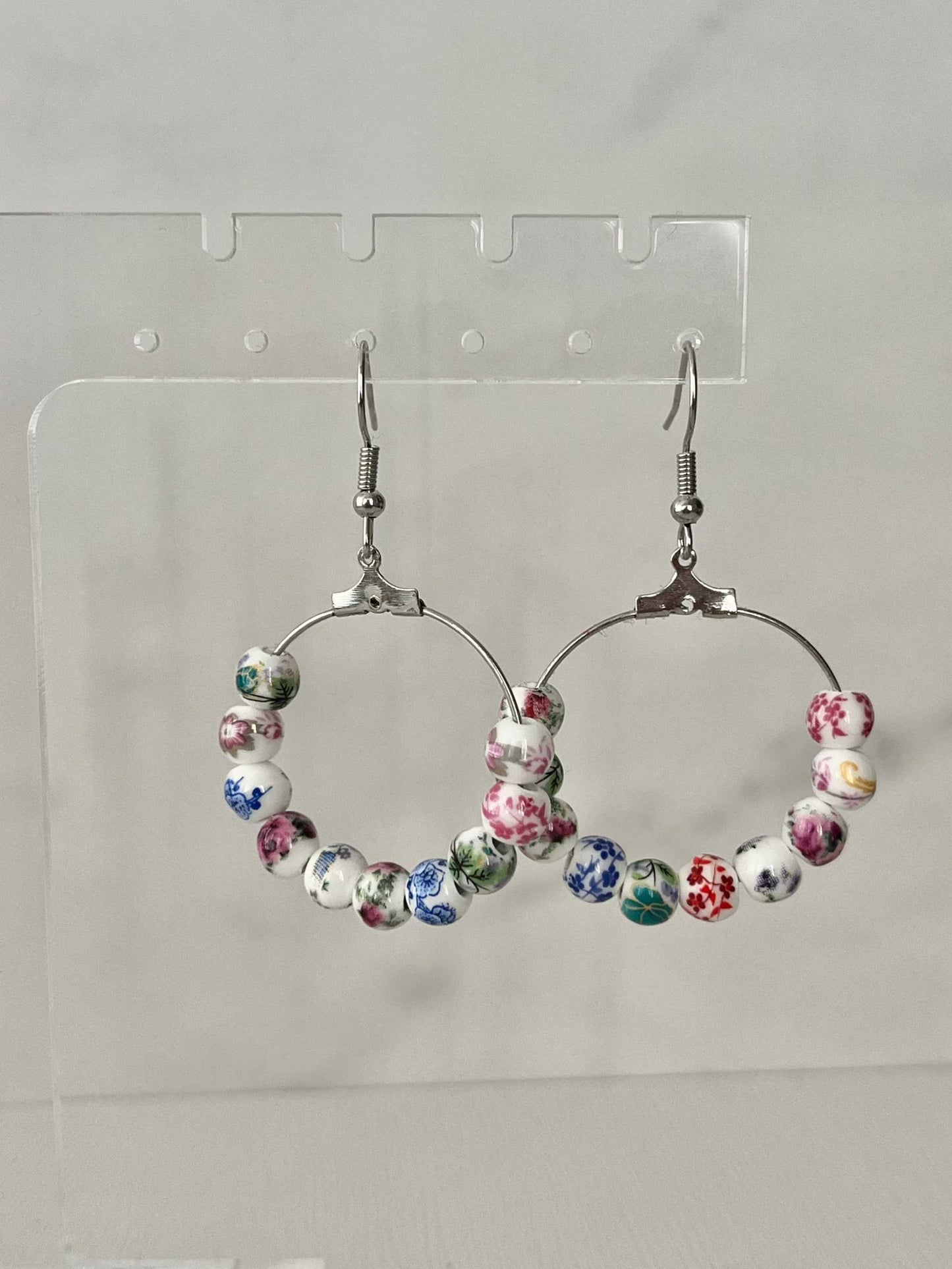 Floral hoop earrings – multicolored beaded silver jewelry with a floral design.

