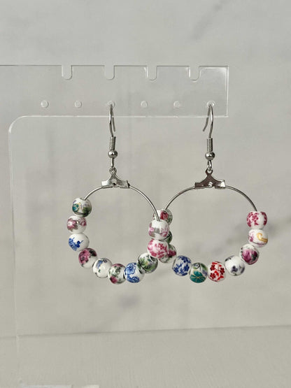 Floral hoop earrings – multicolored beaded silver jewelry with a floral design.

