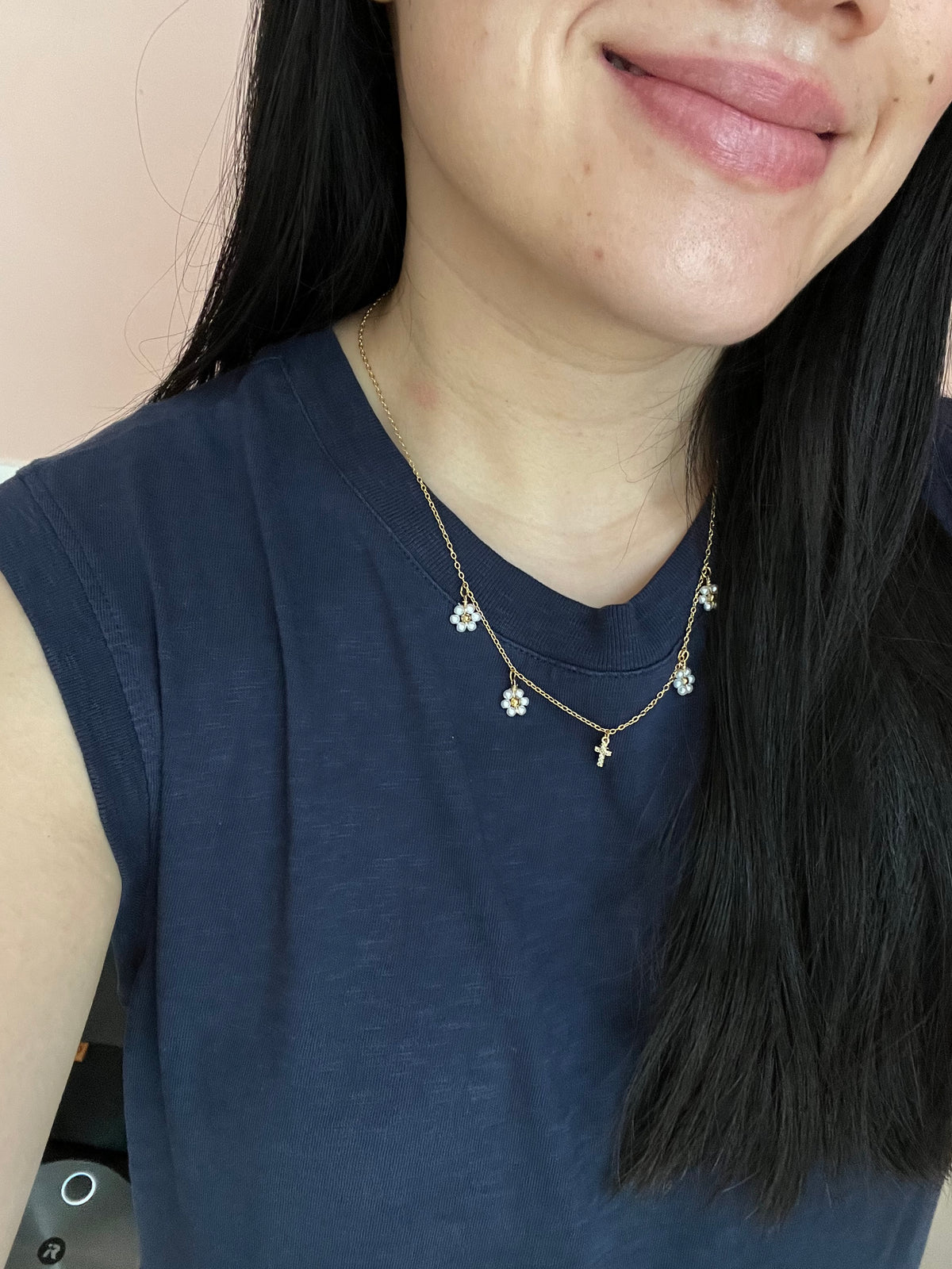 Gold Necklace with 16K gold pendant featuring daisies and a cross.