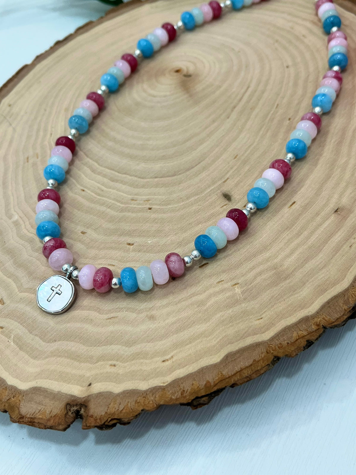 Christian cross necklace with colorful stone beads, silver accents, and pearlescent cross charm