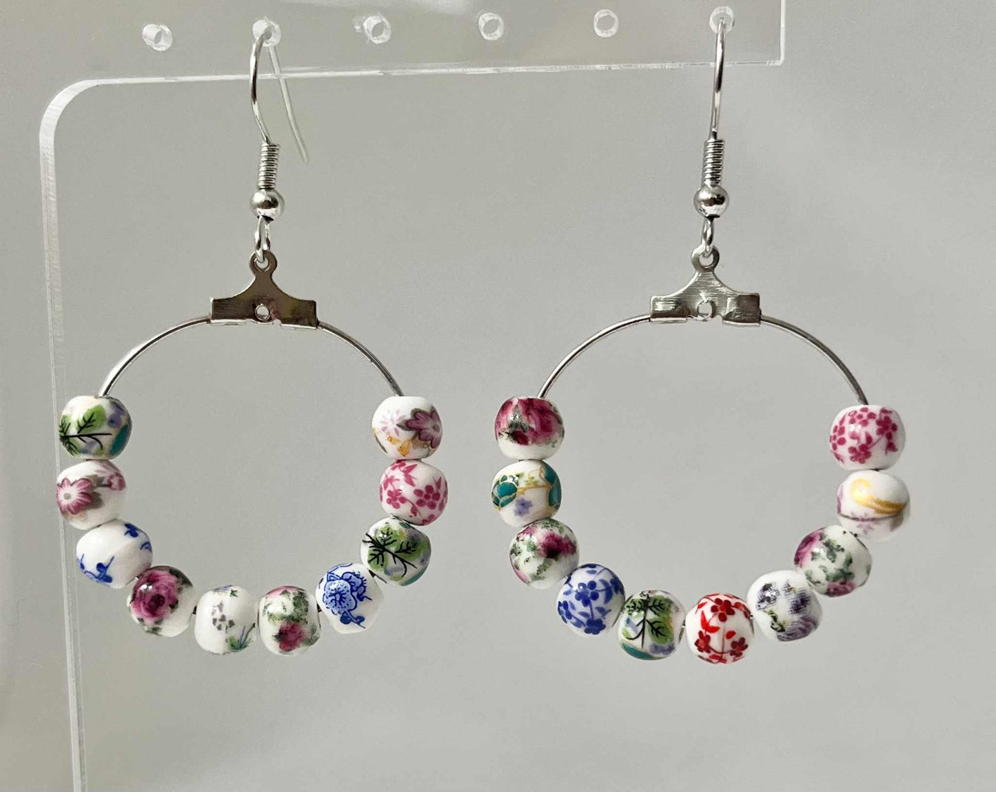 Floral hoop earrings – multicolored beaded silver jewelry with a floral design.

