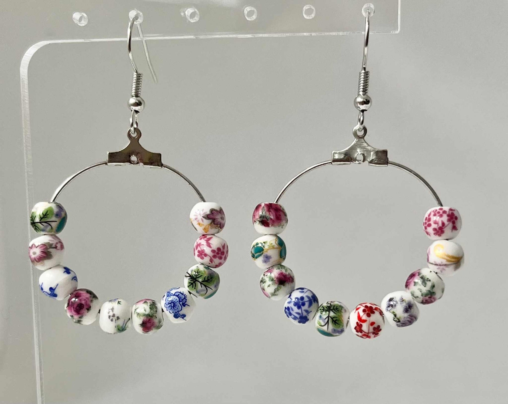Floral hoop earrings – multicolored beaded silver jewelry with a floral design.

