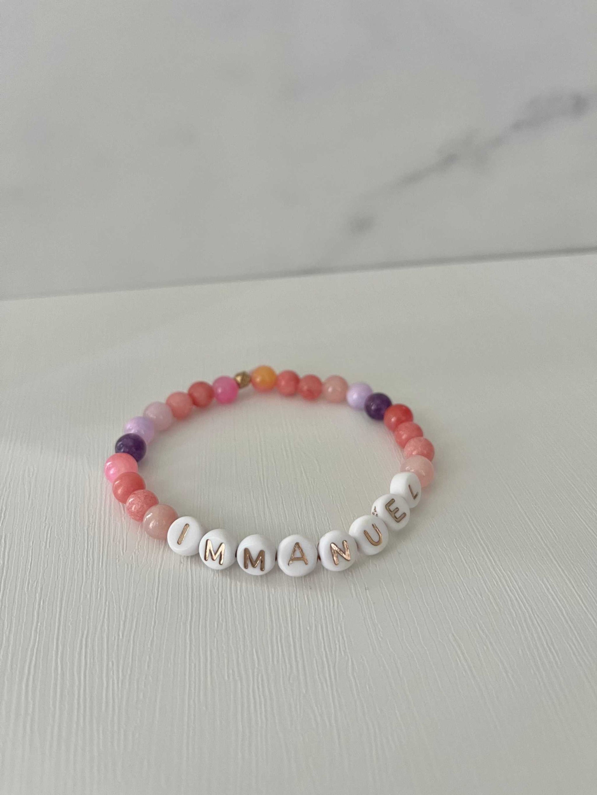 Pink purple IMMANUPink Purple IMMANUEL Bracelet showcasing vibrant pink and purple beads, ideal for expressing faith and style in your jewelry collection.EL stone beaded bracelet
